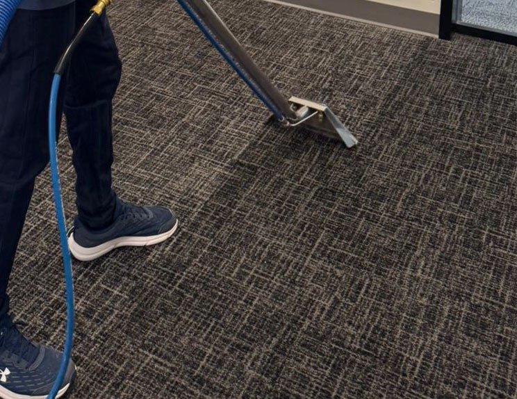 A professional cleaning technician dusting a work surface in a home in Ottawa.